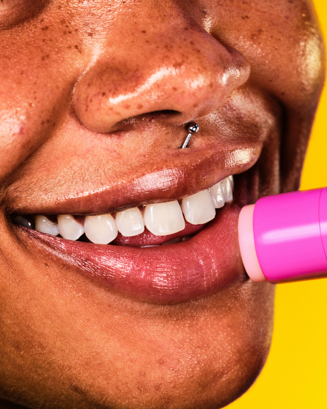 A model applies moisturizing Starface Star Balm Starfruit lip balm on their lips. Tastes bright, juicy, and tropical.