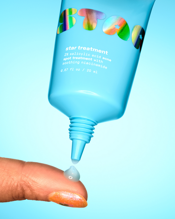 The blue-tinted Starface Star Treatment™ acne spot treatment on a fingertip. A 2% salicylic acid gel that dries clear.